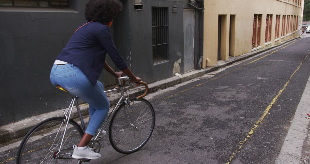 Young Woman Cycling Down Narrow Urban Street - Free Images, Stock Photos and Pictures on Pikwizard.com