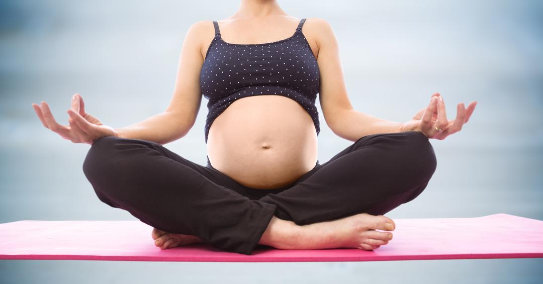 Pregnant woman meditating against blurry blue wood panel - Free Images, Stock Photos and Pictures on Pikwizard.com