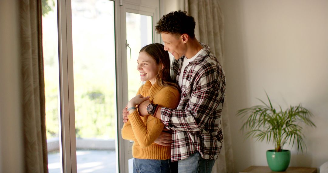 Happy Couple Embracing by Sunny Home Window