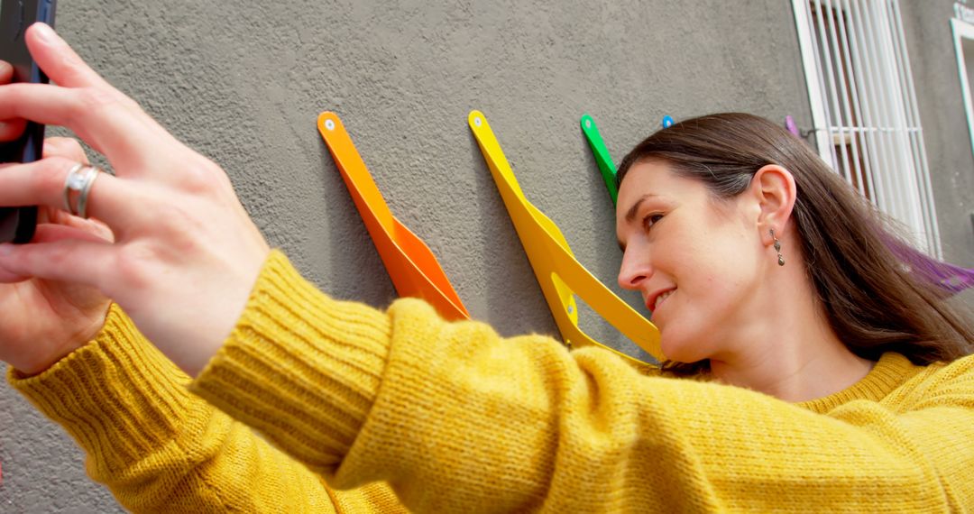 Young Woman Taking Selfie with Colorful Wall - Free Images, Stock Photos and Pictures on Pikwizard.com