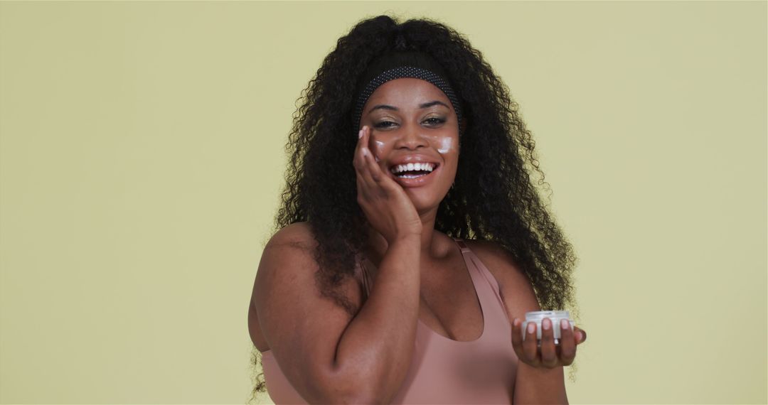 Smiling Woman Applying Facial Cream Promoting Skincare Routine