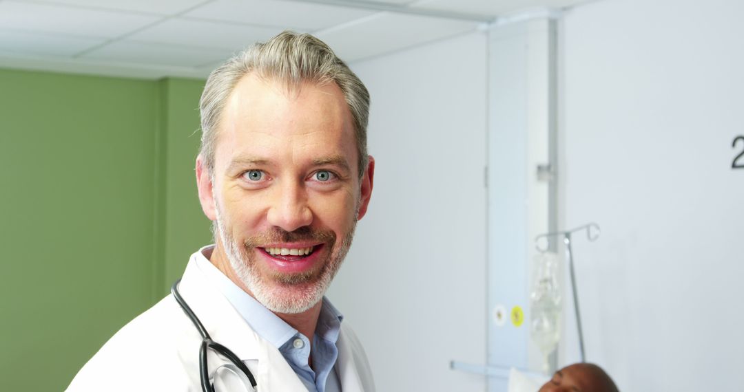 Smiling Caucasian Male Doctor in Hospital with Patient in Background - Free Images, Stock Photos and Pictures on Pikwizard.com