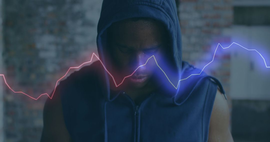 Man in Hoodie with Digital Waves in Abandoned Warehouse
