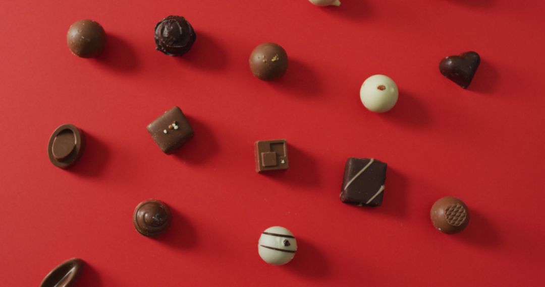 Assorted Chocolates on Red Background Symbolizing Love