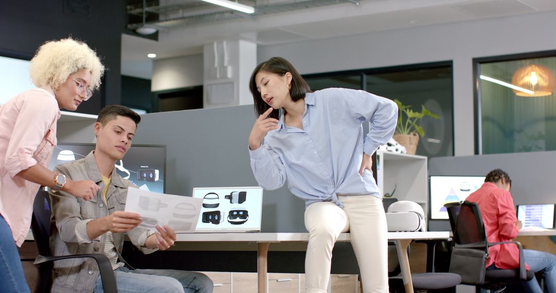 Diverse Team Reviewing VR Headset Designs in Modern Office