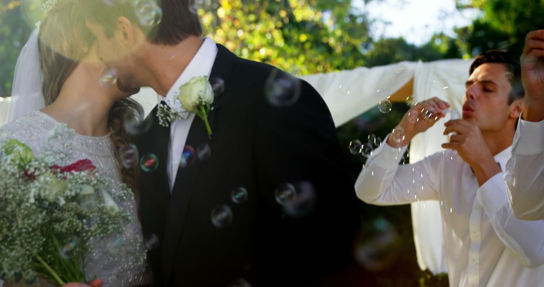 Groom and Bride Kissing at Wedding with Guests Blowing Bubbles - Free Images, Stock Photos and Pictures on Pikwizard.com