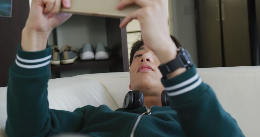 Teen Relaxing at Home Playing Games on Tablet