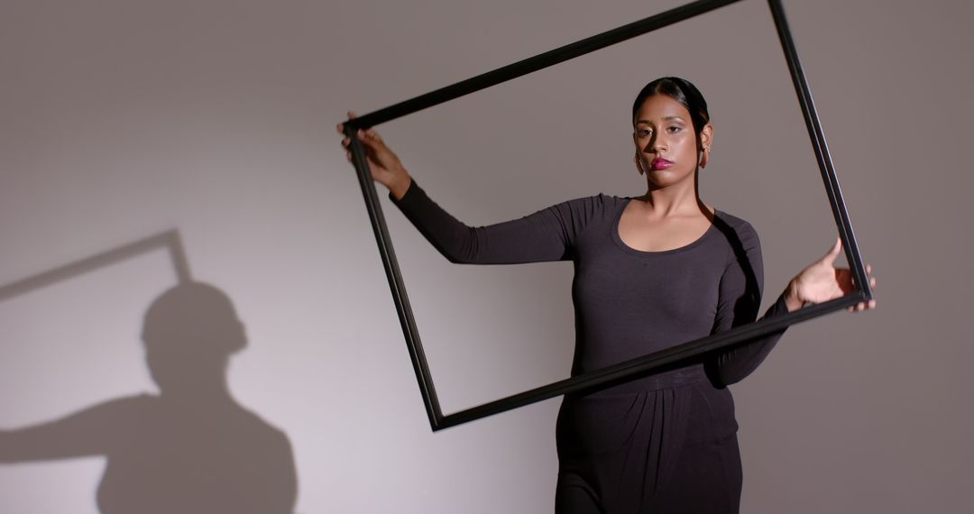 Monochrome Elegance: Woman Aligns Picture Frame