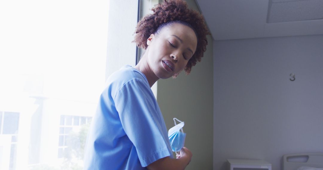 Female Nurse Cleaning with Removing Face Mask by Window - Free Images, Stock Photos and Pictures on Pikwizard.com