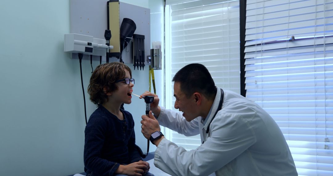 Pediatrician examining young boy with otoscope during check-up - Free Images, Stock Photos and Pictures on Pikwizard.com