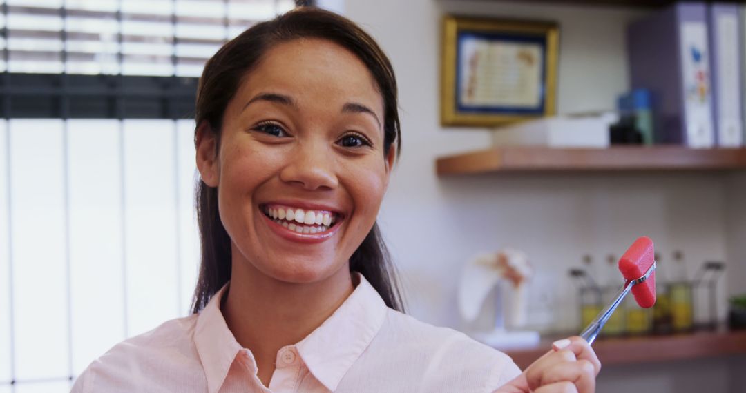 Happy Dentist Holding Dental Tool in Clinic - Free Images, Stock Photos and Pictures on Pikwizard.com