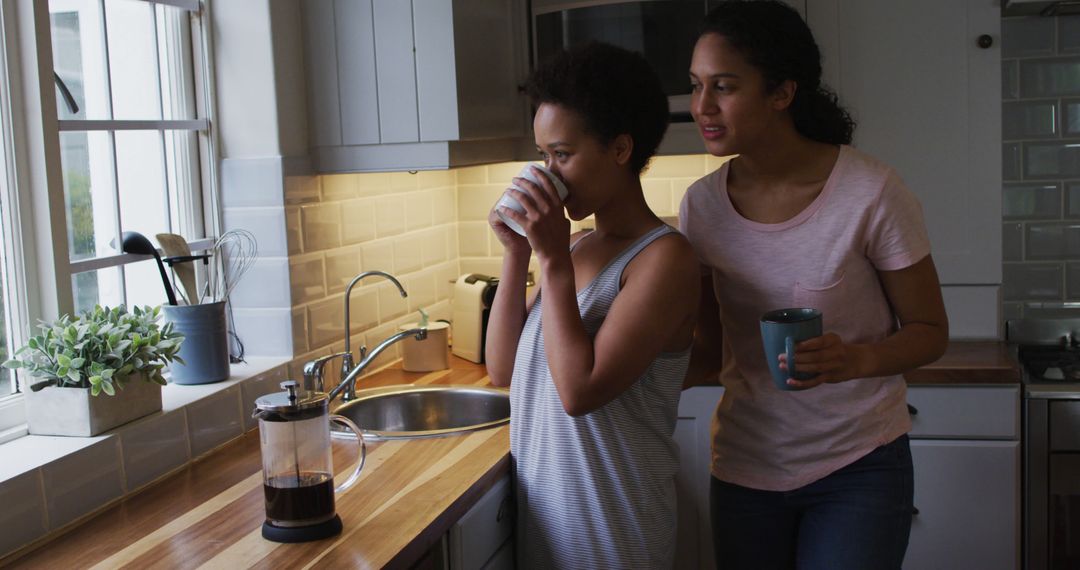 Two African American Women Drinking Coffee in Modern Kitchen - Free Images, Stock Photos and Pictures on Pikwizard.com