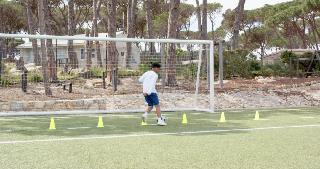 Boy Practicing Soccer Dribbling Drills on Synthetic Field