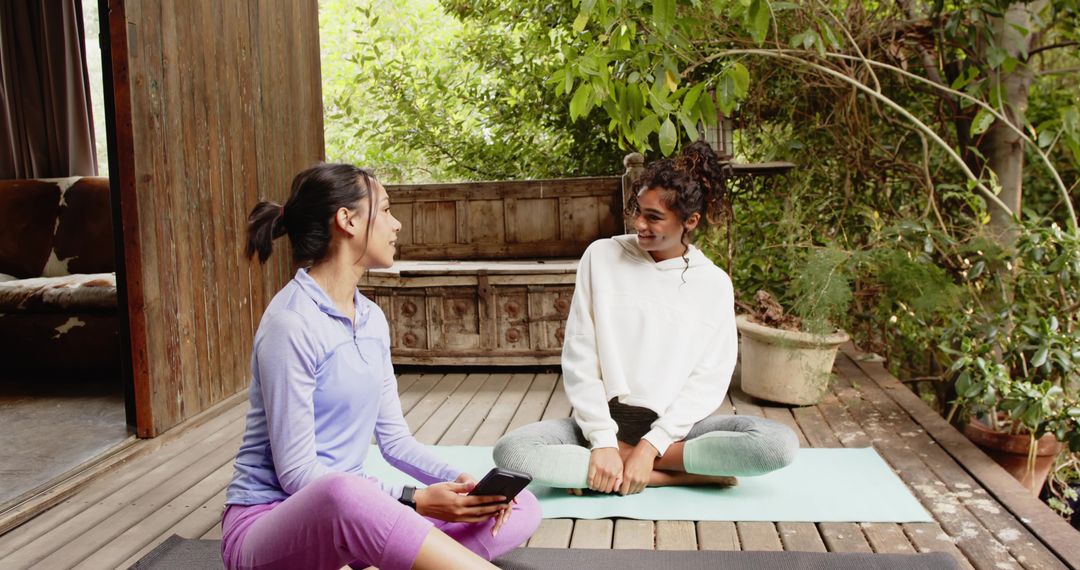 Friends Relaxing on Yoga Mats Engaged in Conversation