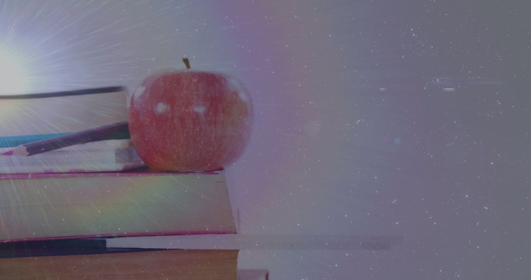 Apple on Books with Dreamy Light and Cosmic Background