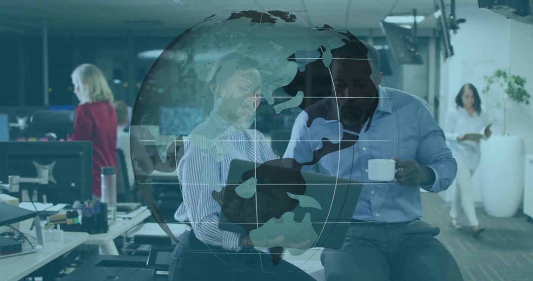 Collaborating over laptop in modern open office with digital globe overlay signaling global teamwork