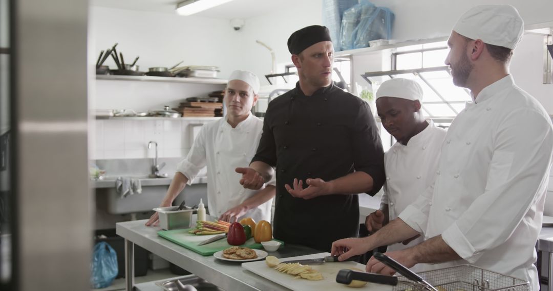 Experienced Chef Instructing Diverse Trainees in Modern Kitchen - Free Images, Stock Photos and Pictures on Pikwizard.com