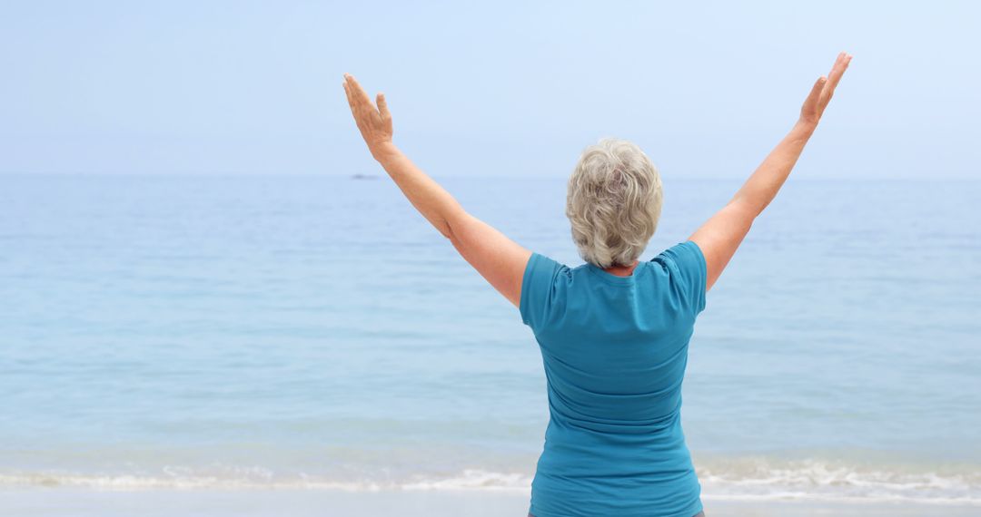 Senior Woman Enjoying Beach with Arms Raised - Free Images, Stock Photos and Pictures on Pikwizard.com