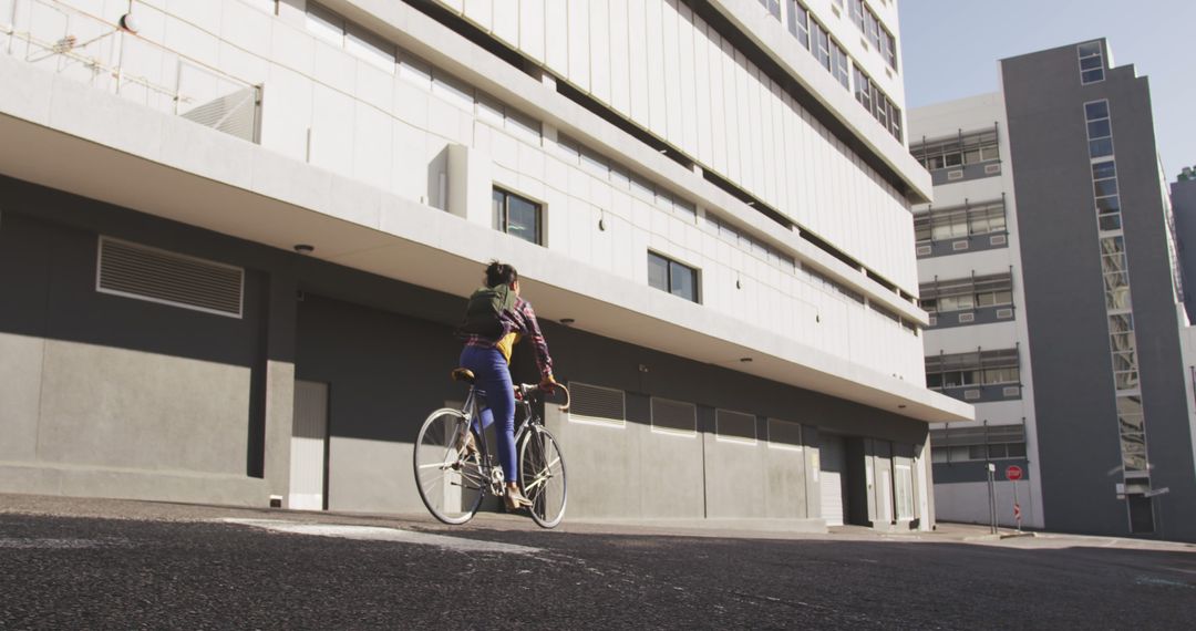 Cyclist in urban environment with modern building background - Free Images, Stock Photos and Pictures on Pikwizard.com