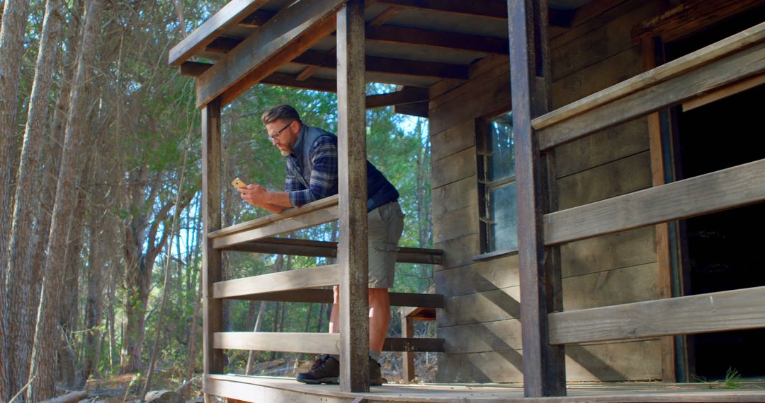 Man Relaxing on Rustic Cabin Porch in Forest - Free Images, Stock Photos and Pictures on Pikwizard.com