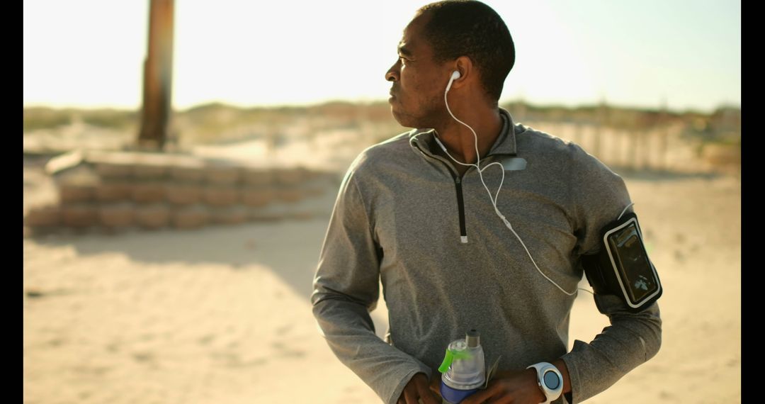 Athletic Man Jogging at Beach with Smartwatch Technology