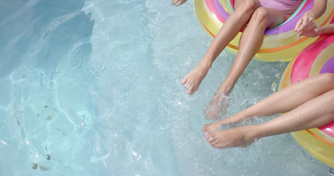 Young Girls Enjoying Pool Time on Inflatable Floats
