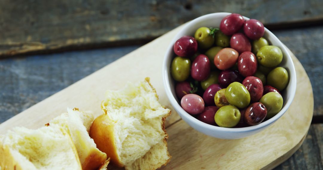 Rustic Snack with Mixed Olives and Fresh Bread on Cutting Board - Free Images, Stock Photos and Pictures on Pikwizard.com