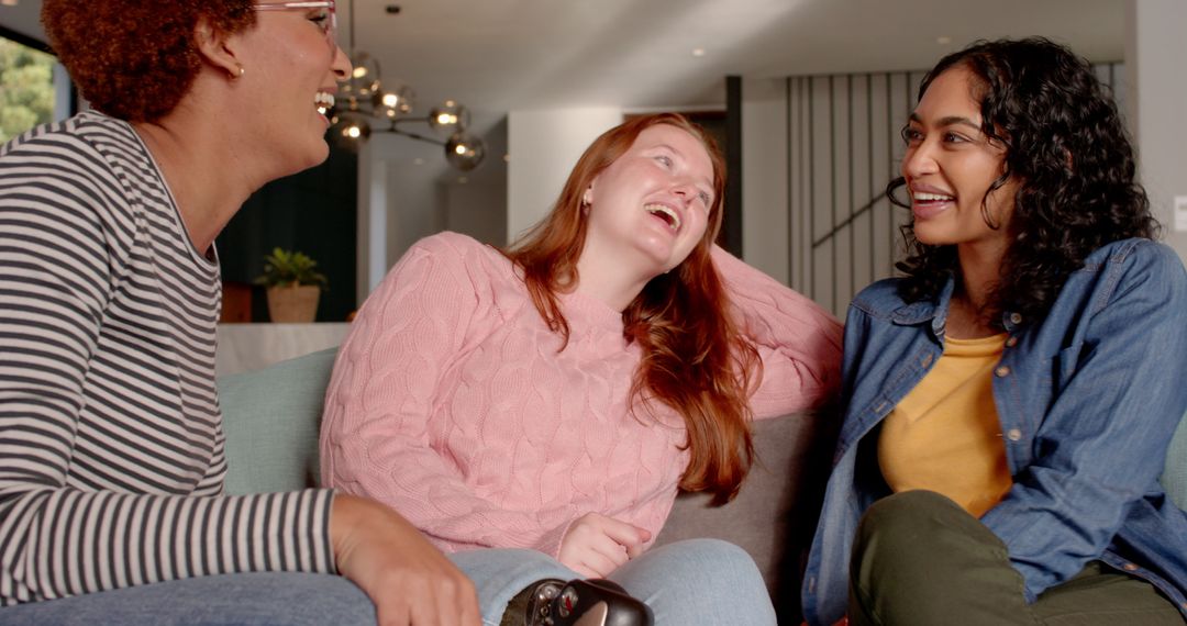 Diverse Friends Laughing Relaxed on Stylish Sofa Enjoying Gaming