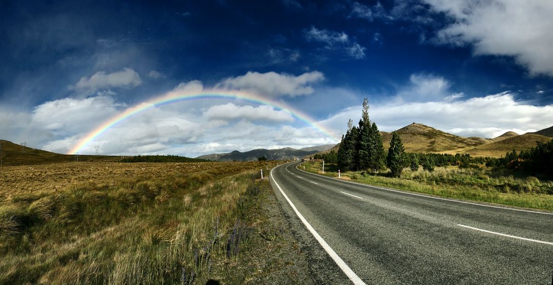 Scenic Mountain Road with Rainbow under Blue Sky - Free Images, Stock Photos and Pictures on Pikwizard.com