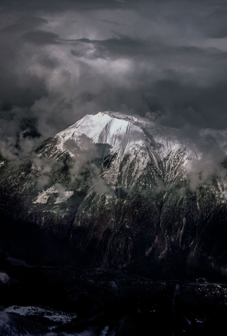 Dramatic Snow-Capped Mountain Shrouded in Dark Clouds - Free Images, Stock Photos and Pictures on Pikwizard.com
