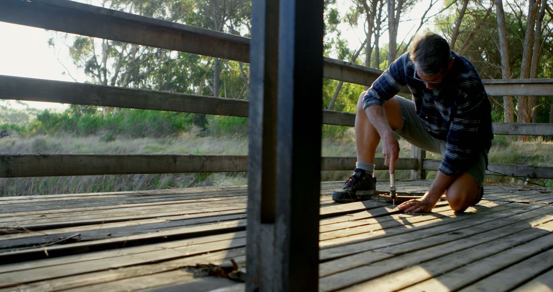 Man Repairing Wooden Deck Outdoors with Carpenter Tools - Free Images, Stock Photos and Pictures on Pikwizard.com