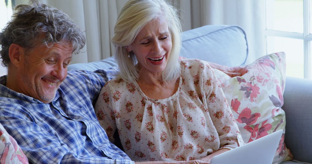 Smiling Senior Couple Using Digital Tablet on Couch at Home - Free Images, Stock Photos and Pictures on Pikwizard.com