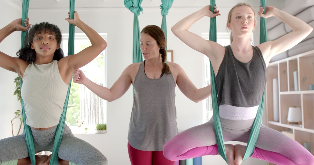 Women Performing Aerial Yoga with Instructor in Modern Studio - Free Images, Stock Photos and Pictures on Pikwizard.com