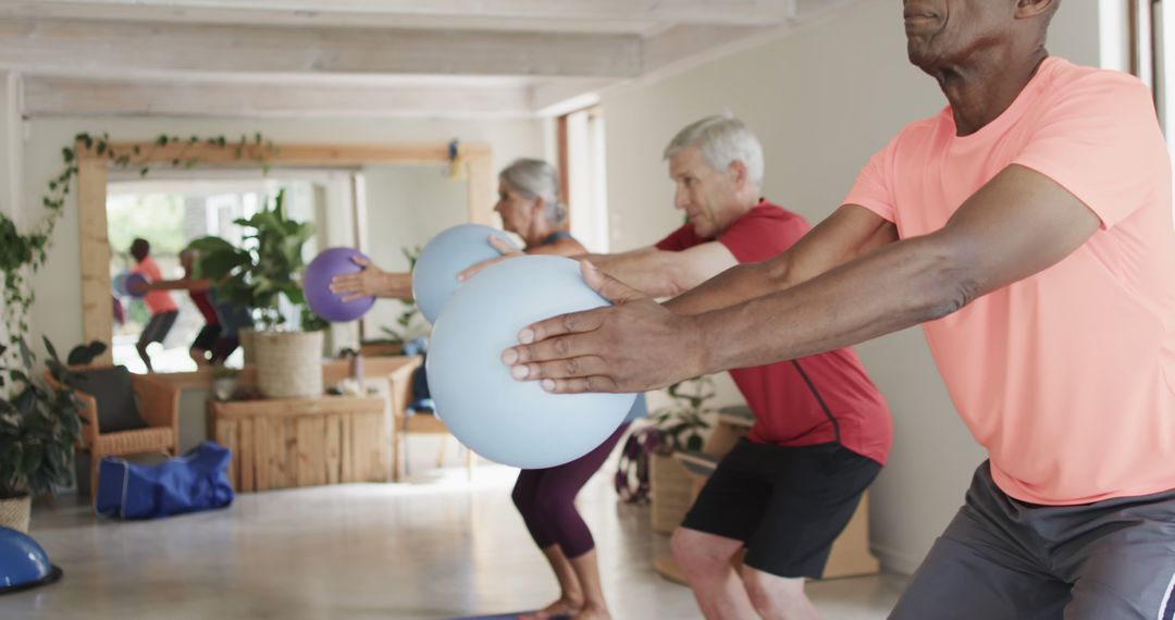 Seniors Exercising with Fitness Balls during Group Workout in Natural Light Room - Free Images, Stock Photos and Pictures on Pikwizard.com