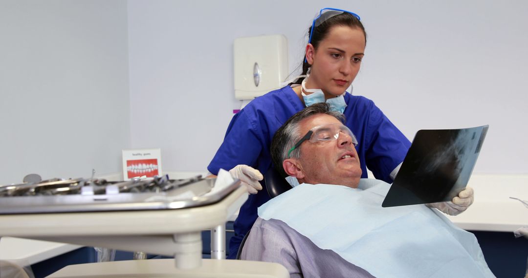 Dental hygienist showing X-ray to senior patient in dental clinic - Free Images, Stock Photos and Pictures on Pikwizard.com