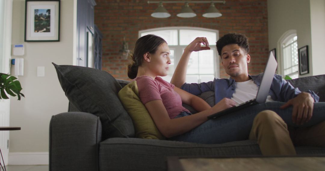 Happy Couple Relaxing on Sofa with Laptop at Home