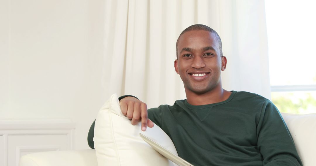 Smiling Man Relaxing on Sofa in Modern Living Room - Free Images, Stock Photos and Pictures on Pikwizard.com