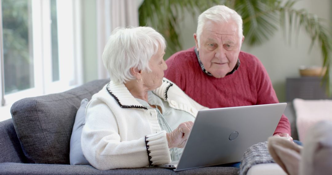 Happy Elderly Couple Enjoying Laptop Together at Home