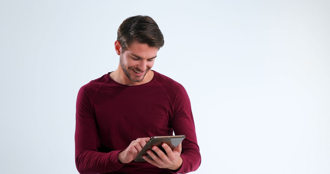 Smiling Man Using Tablet on Plain Background - Free Images, Stock Photos and Pictures on Pikwizard.com