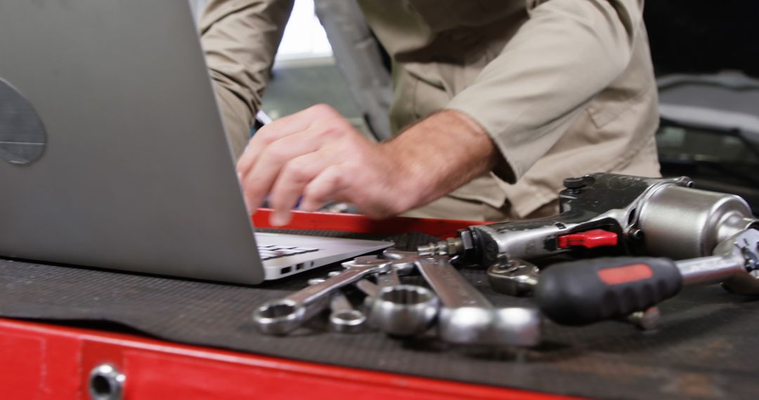 Auto Mechanic Using Laptop to Diagnose Car Issues with Tools on Workbench - Free Images, Stock Photos and Pictures on Pikwizard.com