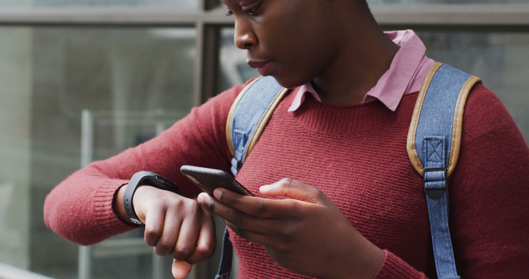 Young Woman Checking Wearable Smartwatch While Using Smartphone Outside - Free Images, Stock Photos and Pictures on Pikwizard.com