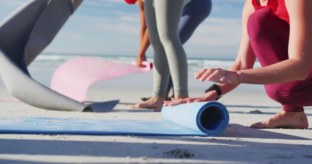 Friends Preparing Yoga Mats on Beach for Outdoor Session - Free Images, Stock Photos and Pictures on Pikwizard.com