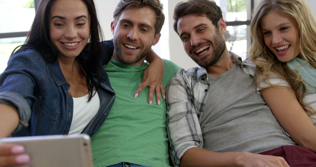 Friends Sitting Close Together Joyfully Taking Spread Selfie on Couch - Free Images, Stock Photos and Pictures on Pikwizard.com