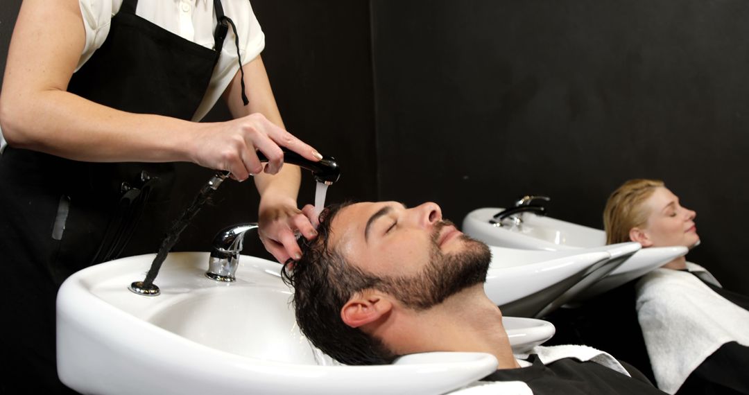 Man enjoys hair wash at professional salon - Free Images, Stock Photos and Pictures on Pikwizard.com