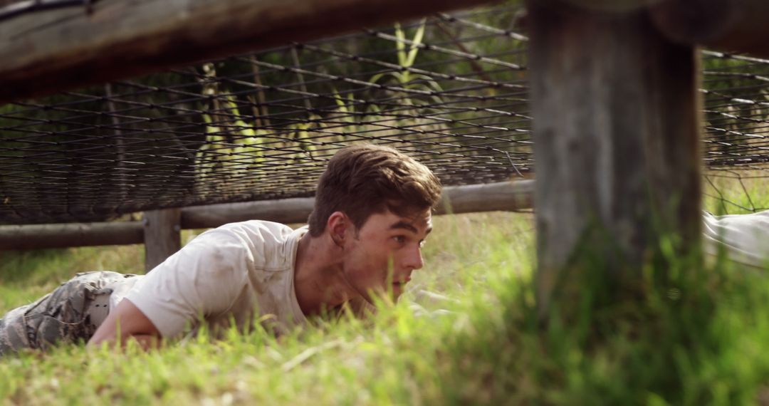 Caucasian Man Crawling Under Obstacle in Outdoor Military Training