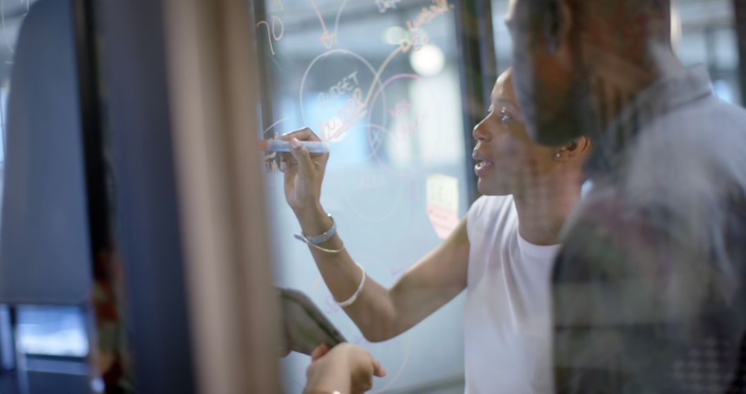 Diverse Office Team Collaborating on Transparent Board