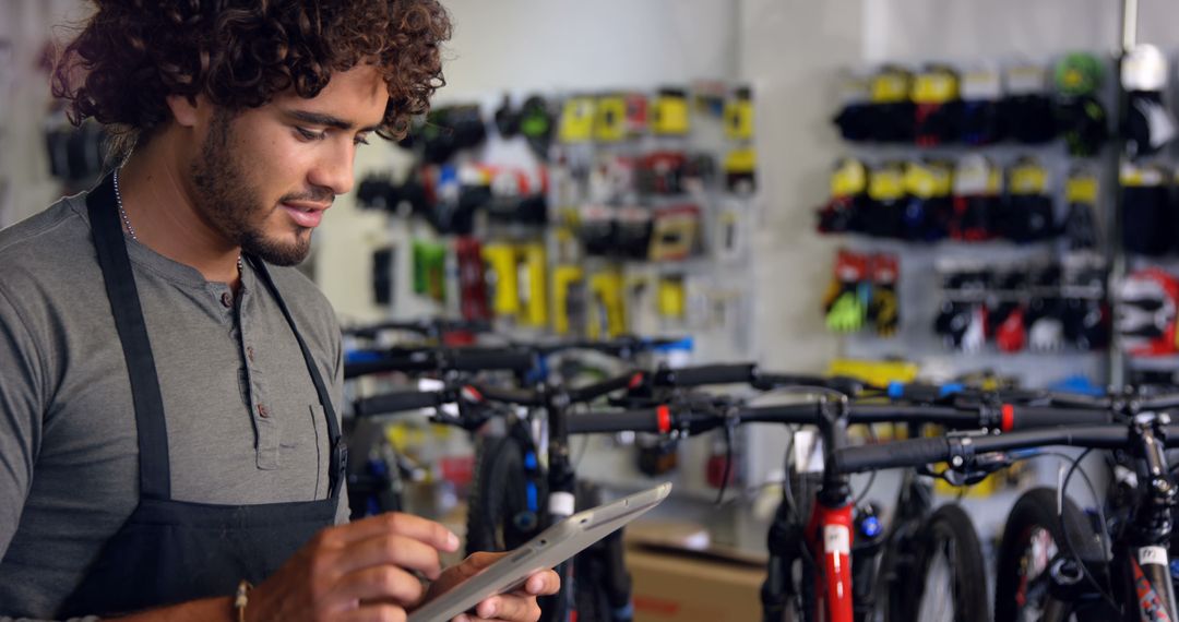 Bicycle Shop Employee Using Digital Tablet in Store - Free Images, Stock Photos and Pictures on Pikwizard.com