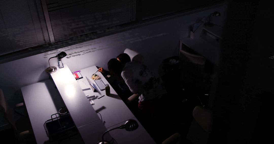 Colleagues Collaborating Over Projected Code In Late Night Office