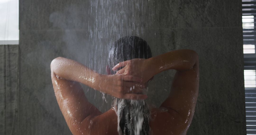 A woman washes her hair in a modern shower, captured in slow motion. - Free Images, Stock Photos and Pictures on Pikwizard.com