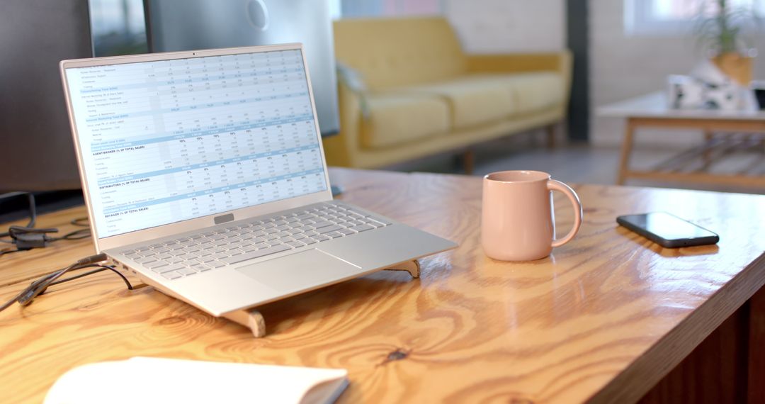 Cozy Workspace with Laptop Showing Sales Tracker Data